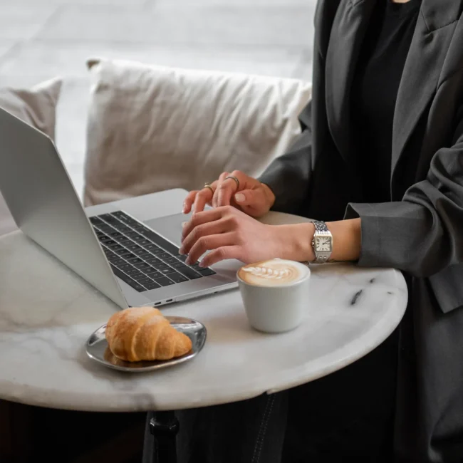 Shopify Theme store Designer working on laptop in cafe